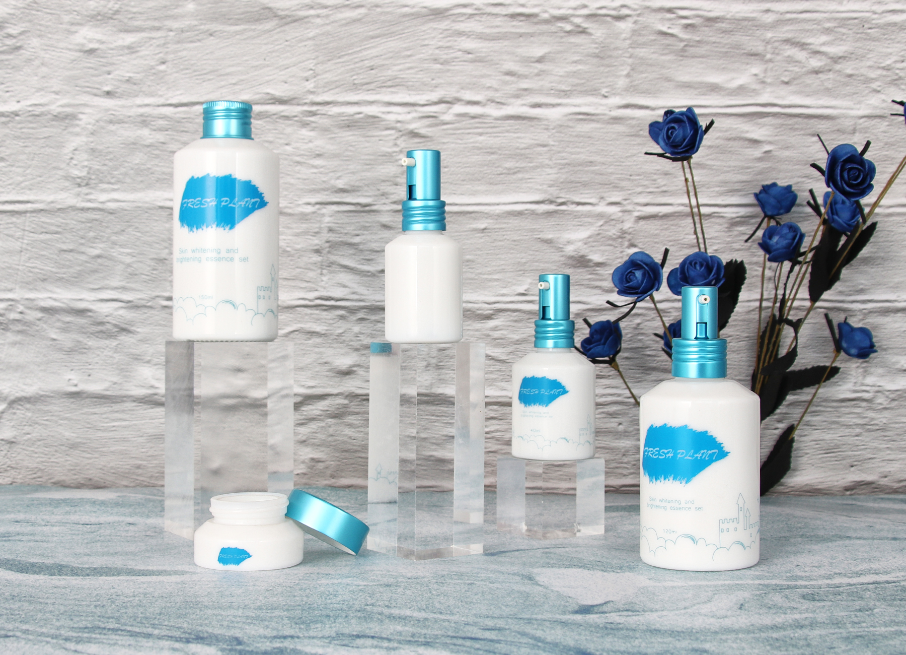 Weiße Glasflaschen und Gläser mit blauen Deckeln